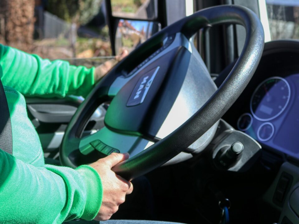 inside a car, a driver in a green sweatshirt is driving