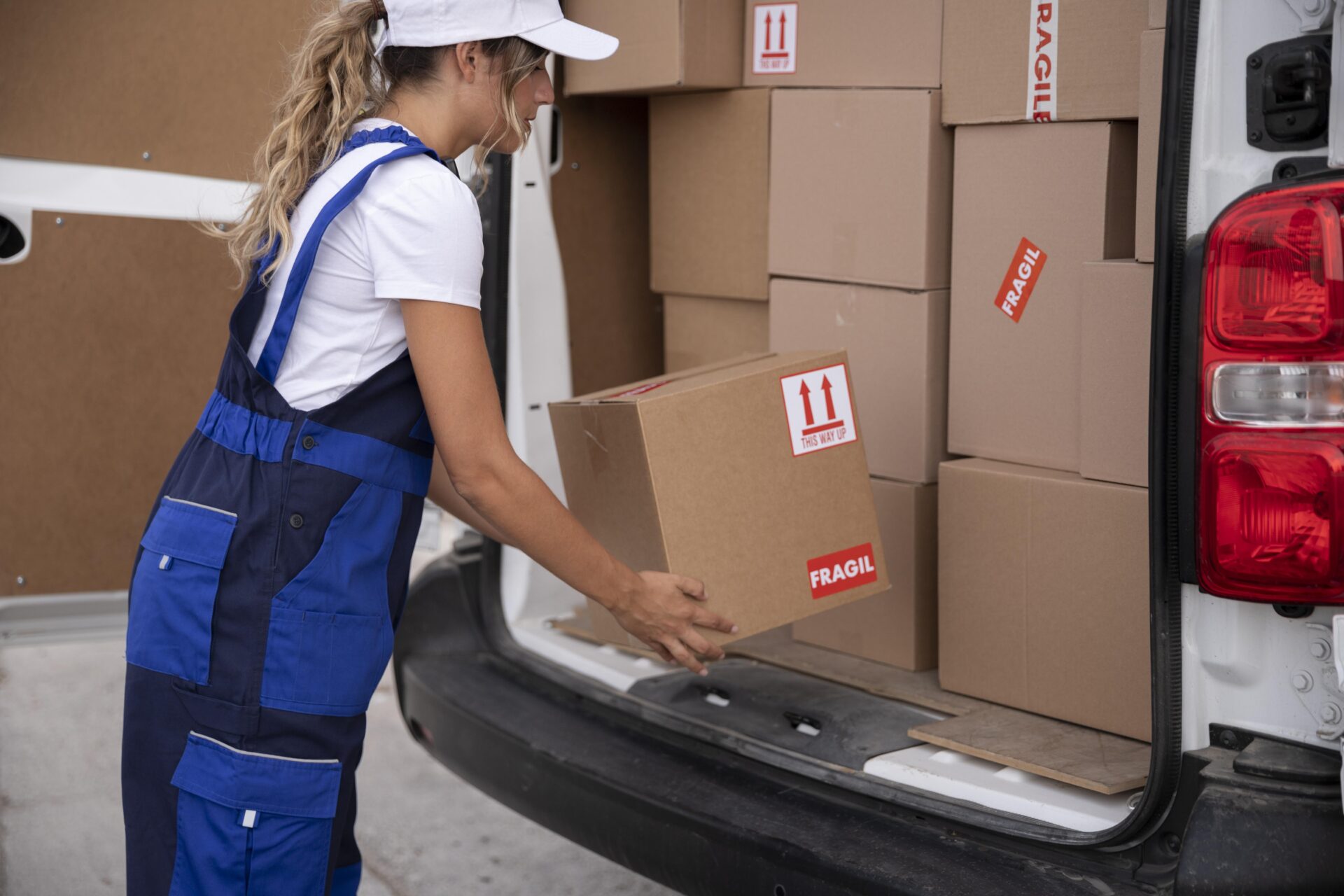 Woman packing multiple boxes into the car