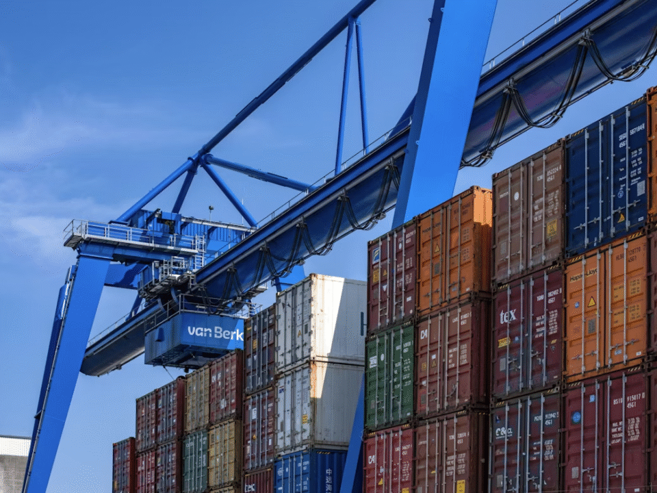 very large crane hovering over logistics containers
