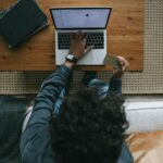 top view - a person sitting in front of a laptop making a card payment