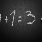 a blackboard with the equation “1+1=3”