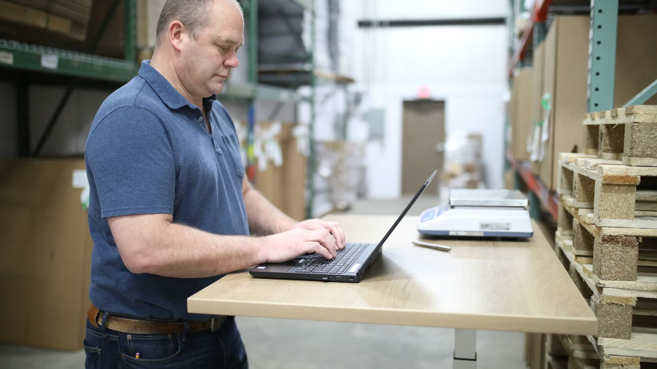 warehouse worker using laptop checking storage data