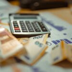 a table with a calculator and banknotes